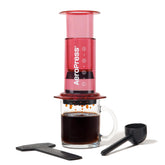 AeroPress Clear Red front view shows portable, shatterproof design for on-the-go coffee