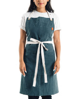 Caldo Linen Kitchen Apron front view in Spruce color with practical pockets for hands-on cooking.