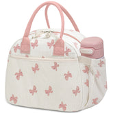 Carry bloom bow pink lunch box with corduroy exterior and front zipper pocket.