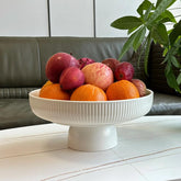 JolieJulie ceramic fruit bowl on counter with fresh fruit, a stylish centerpiece.