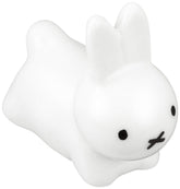 Kaneshotouki Miffy rabbit chopstick rest in white porcelain holding chopsticks.
