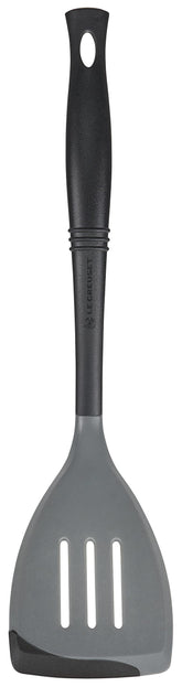 Le Creuset Revolution spatula with oyster finish shows flexible silicone edge for precise flipping.