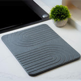 LIFSEZY stone dish drying mat absorbs water quickly on the kitchen counter.