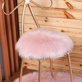 OKAYDA round faux sheepskin chair cover in pink adds luxurious softness to any seat.
