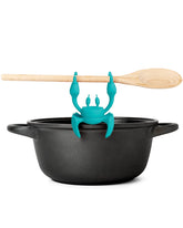 OTOTO Aqua the Crab rests utensils on the stove to reduce countertop mess.