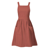 Pinknoke burnt orange cotton linen pinafore apron, front view with pockets for easy cooking.
