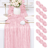 RealBox light pink cheesecloth table runner draped on a dining table for weddings and parties.