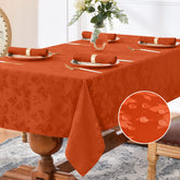 Romanstile jacquard rectangle tablecloth burnt orange on table with elegant floral pattern.