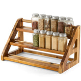 Tinamo acacia wood spice rack on countertop holding 24 jars for easy cooking access.