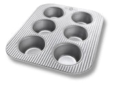 USA Pan 6-cup muffin pan in aluminized steel delivering even heat for consistent muffins.