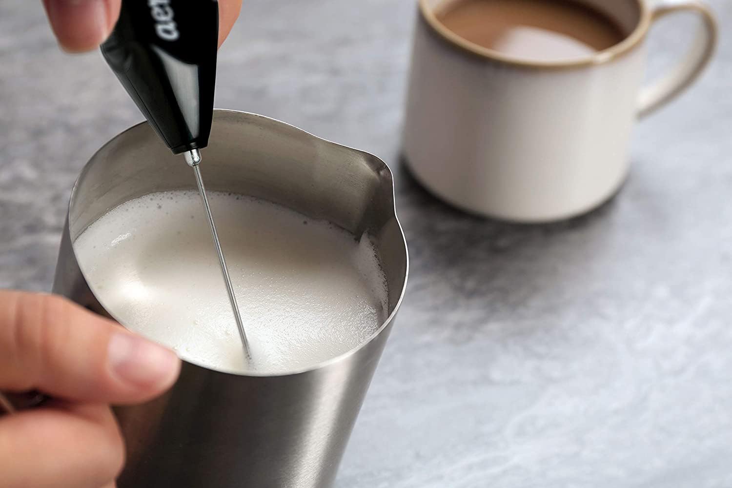 Close-up of the Aerolatte whisk head frothing milk for rich texture.