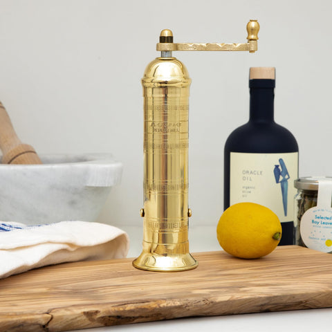 Alexander Home pepper grinder with European-inspired brass design on kitchen counter.