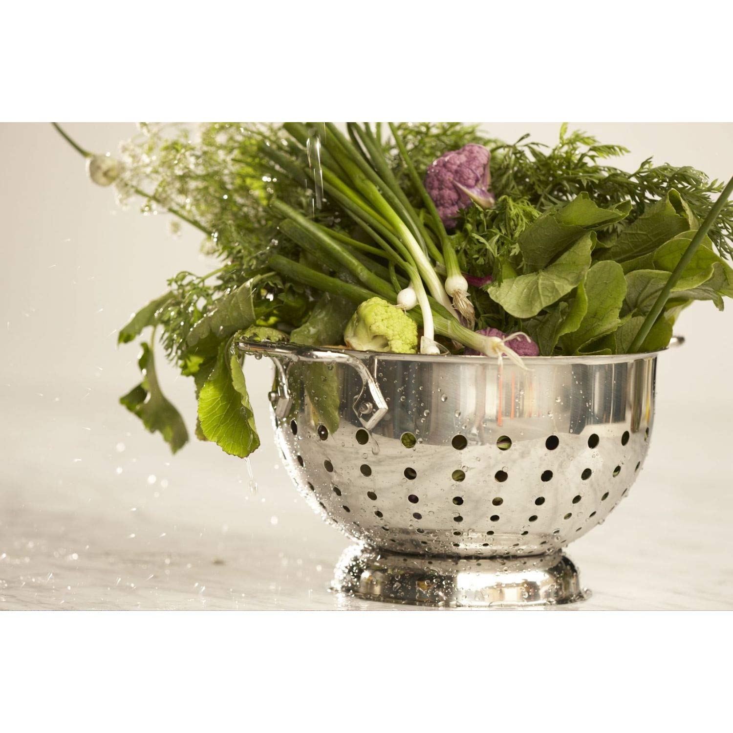 All-Clad colander with brushed interior supports easy prep and clean-up.