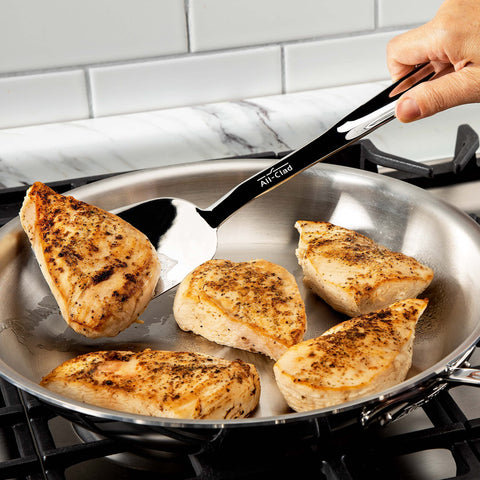 All-Clad turner with comfortable grooved handle, ideal for stir-frying and safe storage.