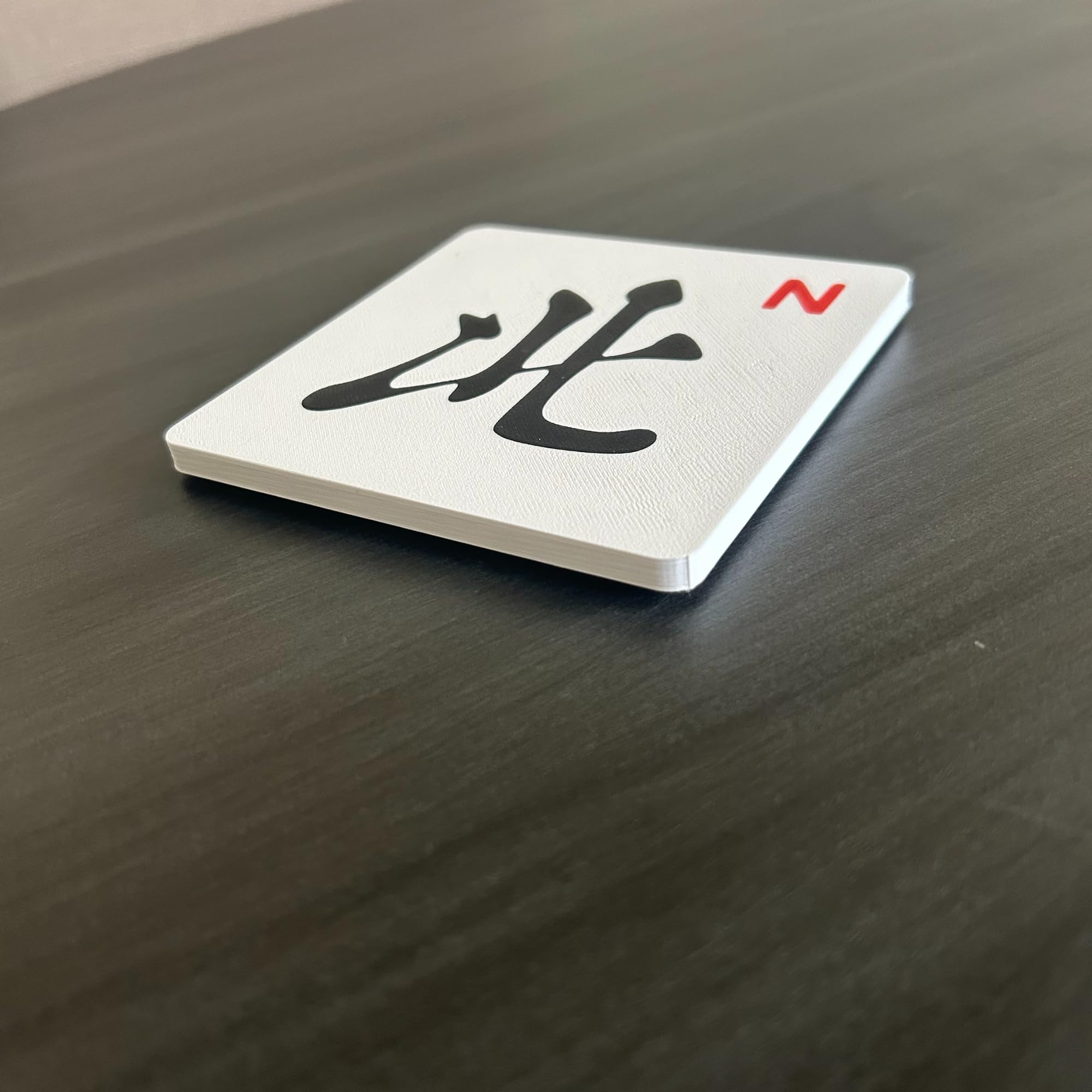 Artful 3D Mahjong North coaster with cork backing for grip.