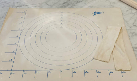 Ateco rolling pin cover on canvas cloth protects dough.