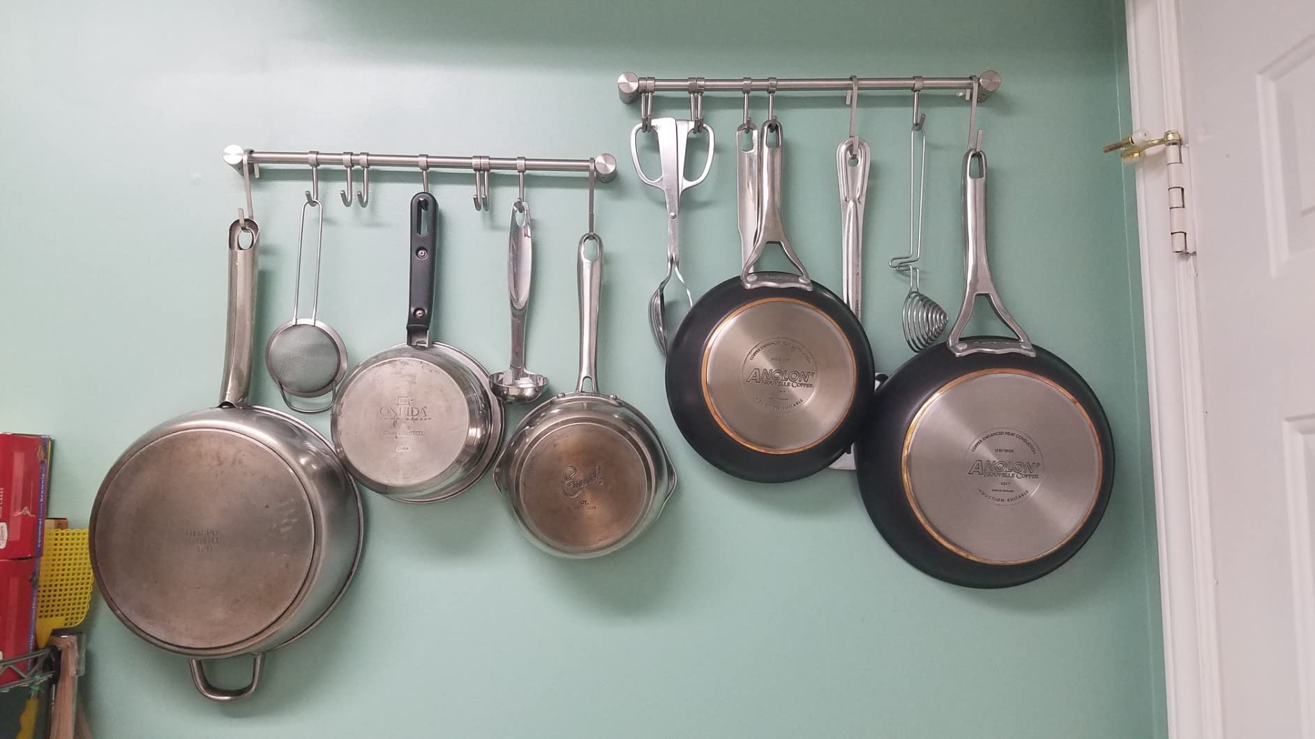 Audmore hanging rack with pots and pans demonstrates space-saving wall mount solution.