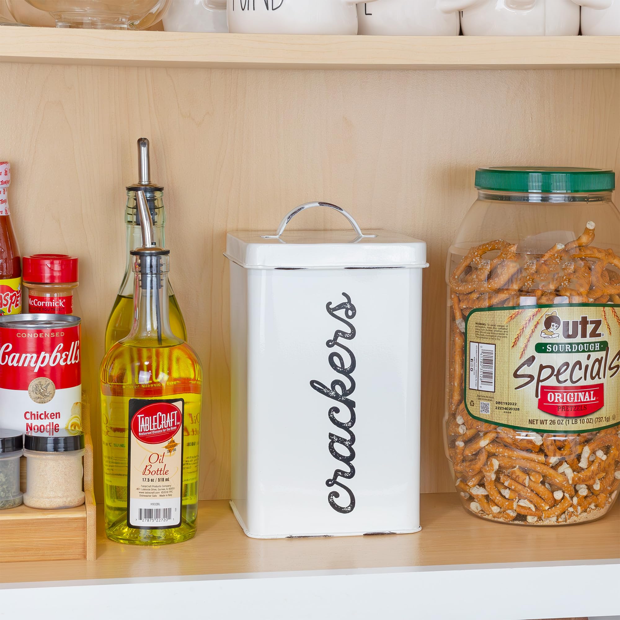 AuldHome Design white cracker storage adds vintage charm to the kitchen counter.