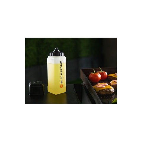 Blackstone squeeze bottle shown beside spices for even flavor distribution while cooking.