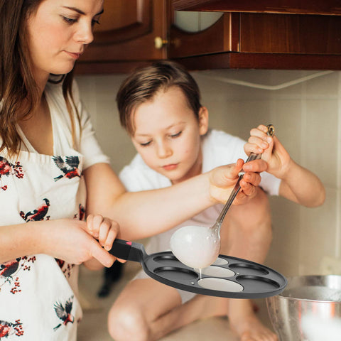 CAINFY Pancake Pan on a gas stove for reliable heating across surfaces.