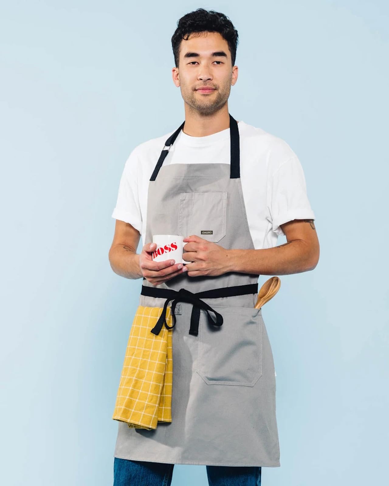 Caldo Daily Cotton Kitchen Apron grey full length on a model in kitchen