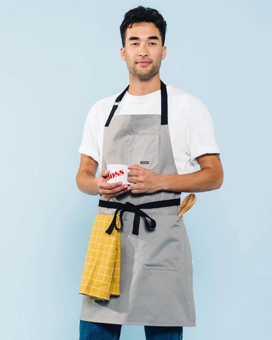 Caldo Daily Cotton Kitchen Apron grey full length on a model in kitchen