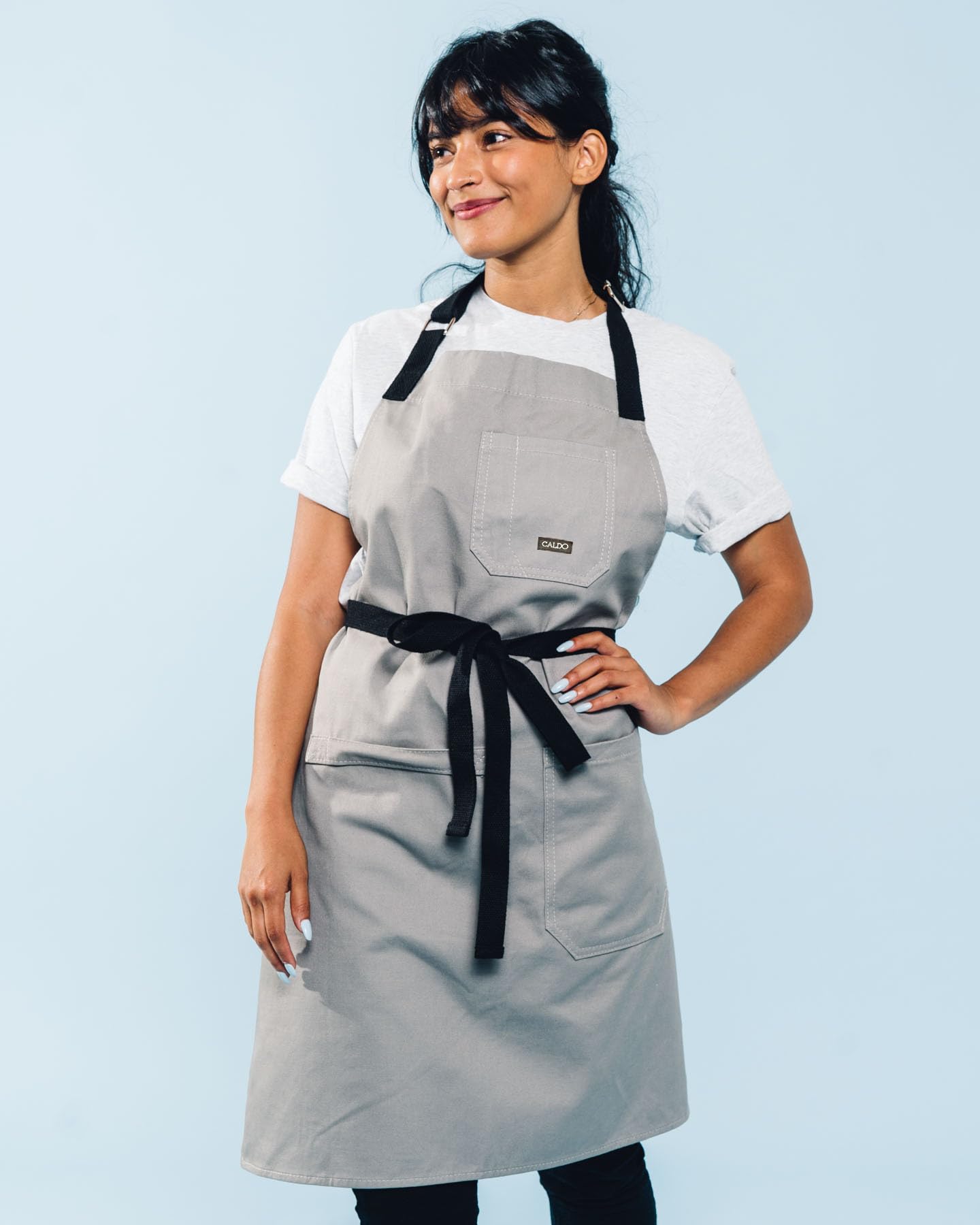 Caldo grey apron showing large pocket on the side for tools during cooking