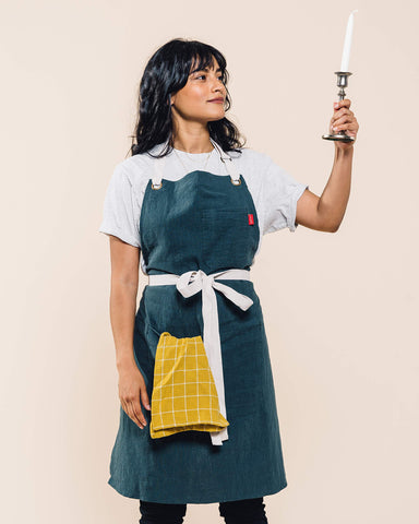 Caldo Linen Kitchen Apron care label highlights simple washing for lasting use.