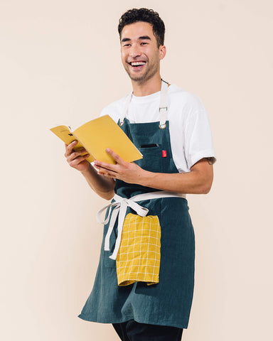 Caldo Linen Kitchen Apron side pocket shows quick access to tools while cooking.