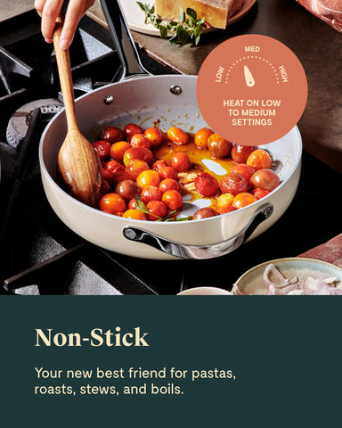 Caraway navy pan on induction-friendly cooktop enables versatile heating.