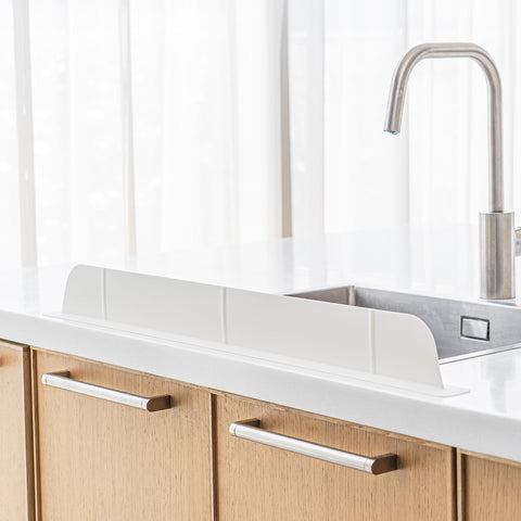 Casa Starlet 30-inch ultra-wide splash guard on sink protecting clothing from splashes.