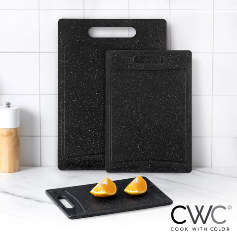Cook with Color small speckled black cutting board for fruit slicing.