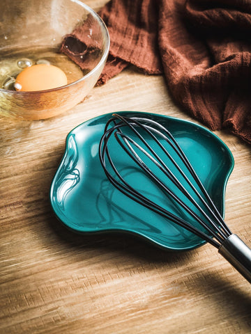 Dark green Cormomu spoon holder on stove top keeping utensils tidy