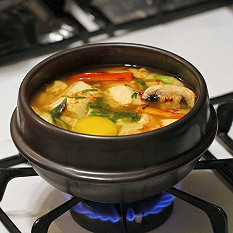 Crazy Korean Cooking black plastic trivet included for heat protection.