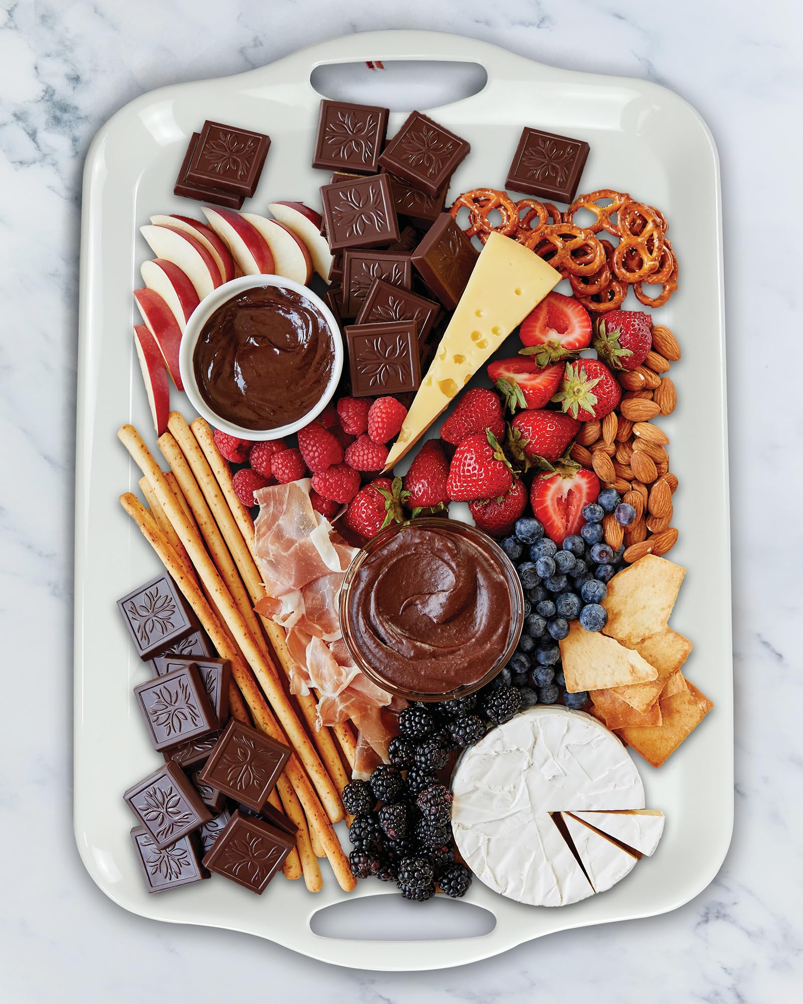 Czlizdyt fruit and snack tray display on white surface.