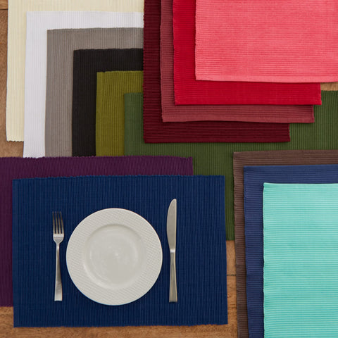 DII dark green placemats complement plates and glassware in a dining scene.