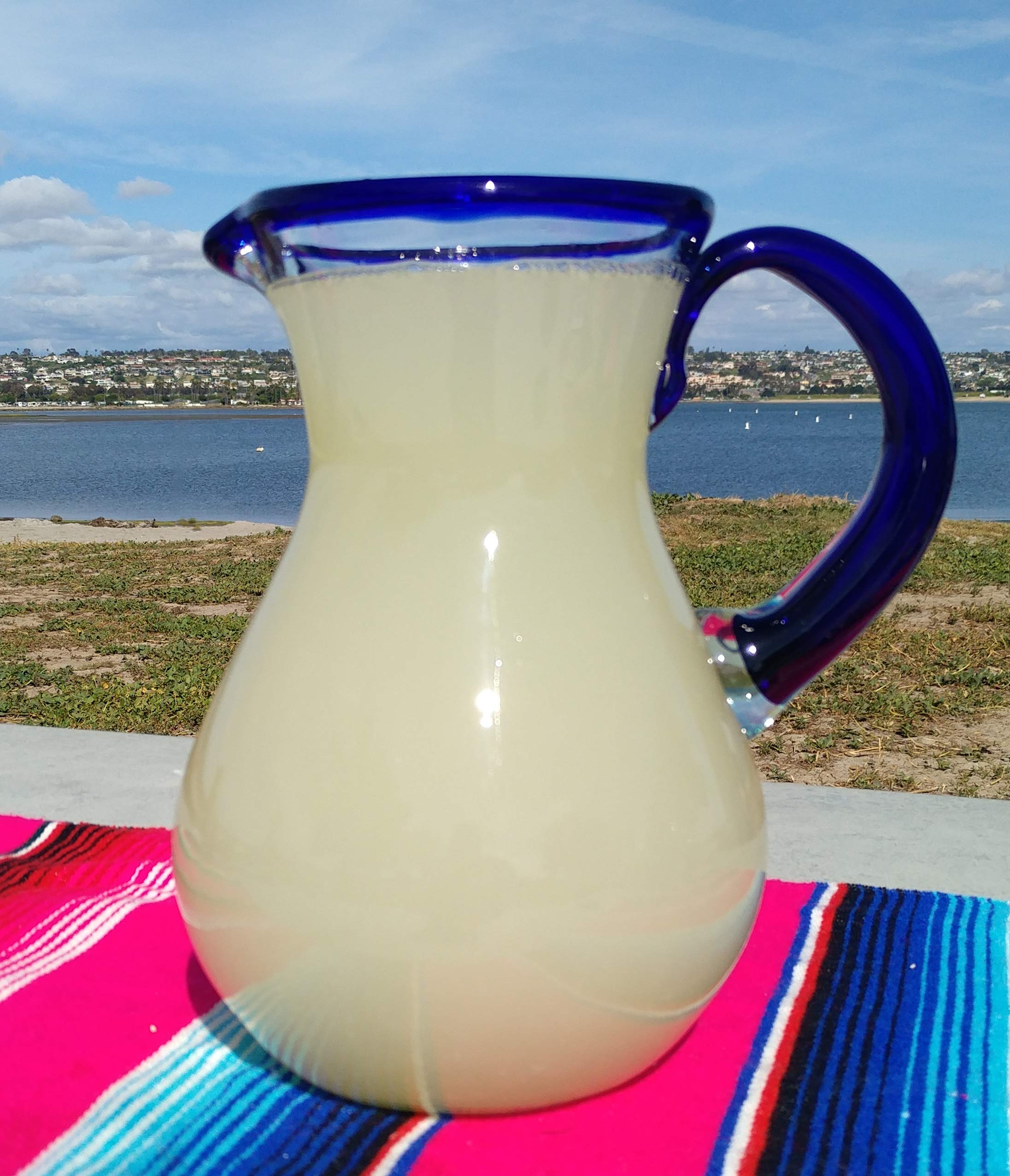 Dos Sueños pitcher side view with cobalt blue handle for easy pouring.