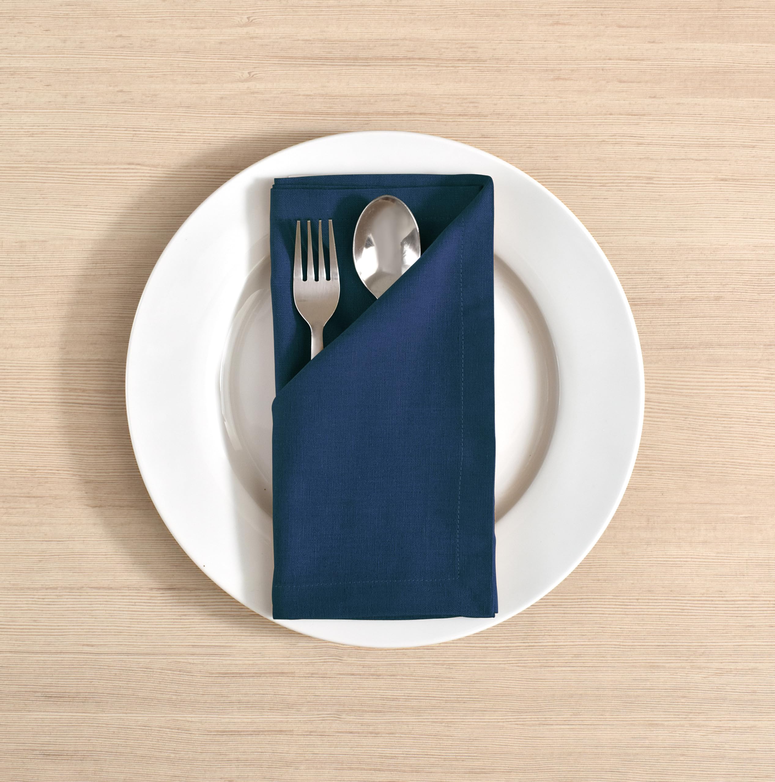 Fingercraft navy napkins with mitered corners, premium hotel-style detail.
