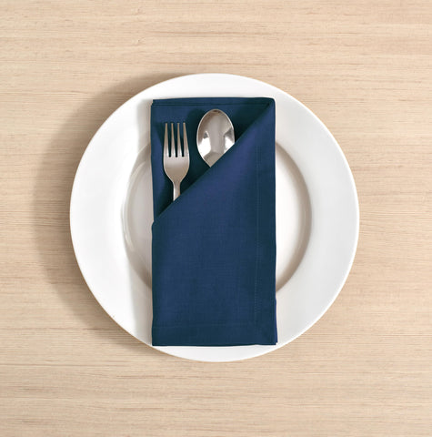 Fingercraft navy napkins with mitered corners, premium hotel-style detail.