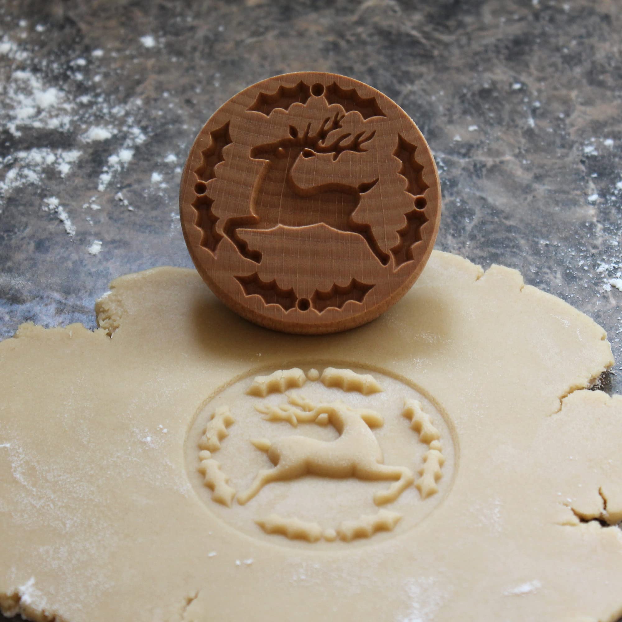 Fun Food Tools wood cookie stamp closeup shows the carved Reindeer and Holly design.