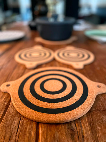 Generic magnet cork-trivet beside cookware in a busy kitchen