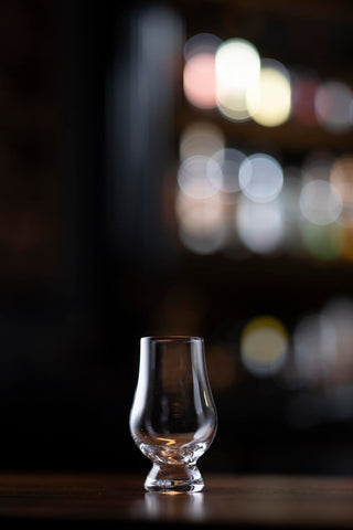Hand holding Glencairn Wee glass to savor a small dram.