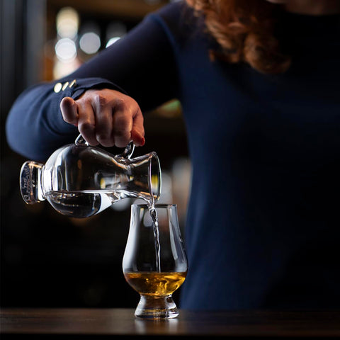 Glencairn whiskey glass held in hand to illustrate comfortable grip.