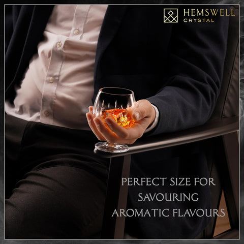 Hemswell Crystal stemmed snifter cradled between fingers, elegance for refined gatherings