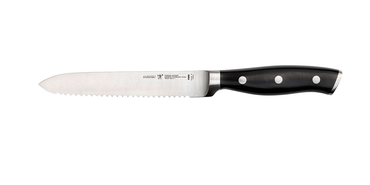 HENCKELS Forged Accent 5-inch serrated utility knife blade designed for precise tomato slicing.