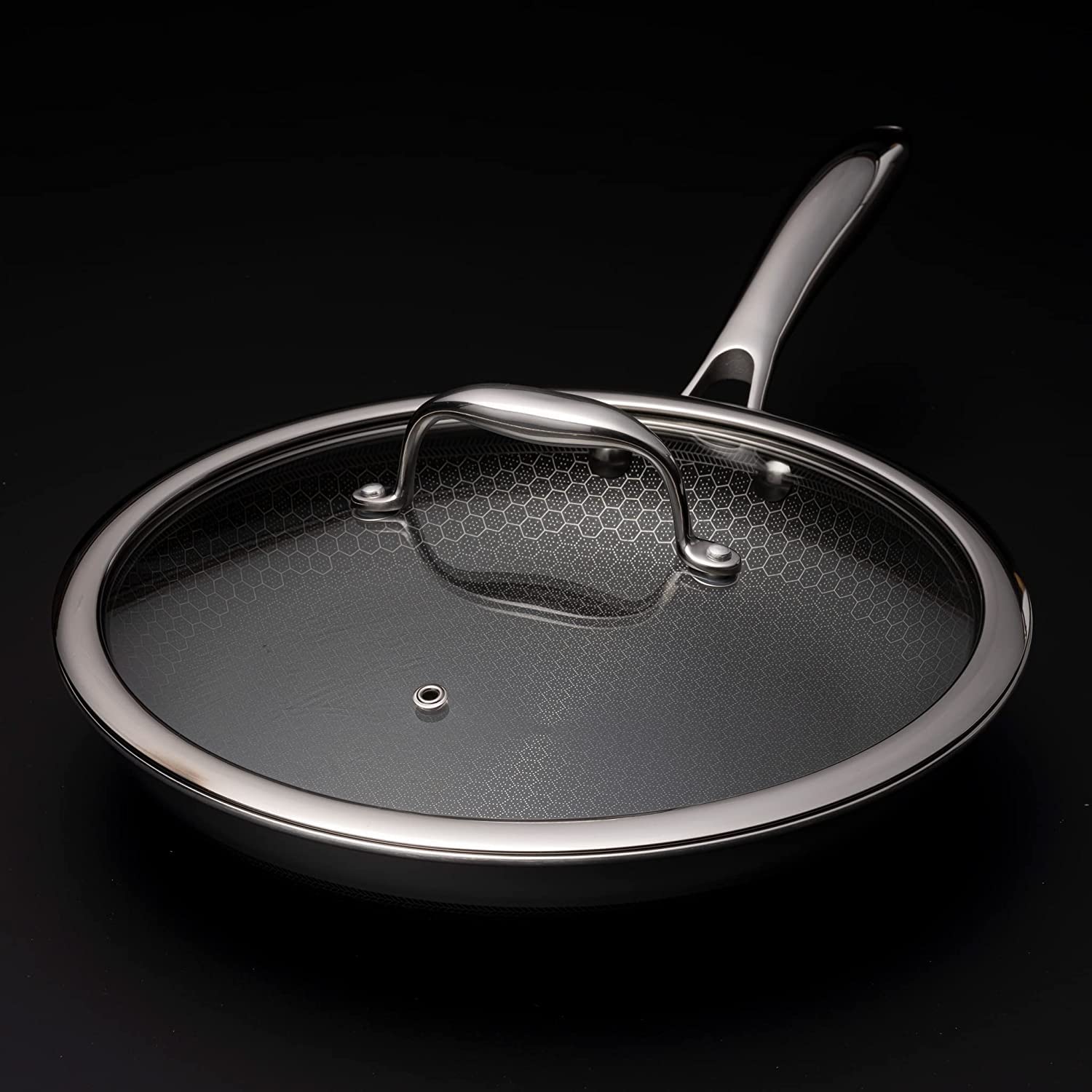 HexClad lid with stay-cool handle and steam vent, easy safe removal during cooking.