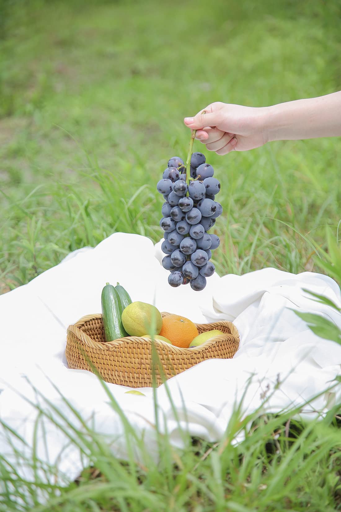 HITOMEN round bread basket on kitchen counter displaying fruit and bread.