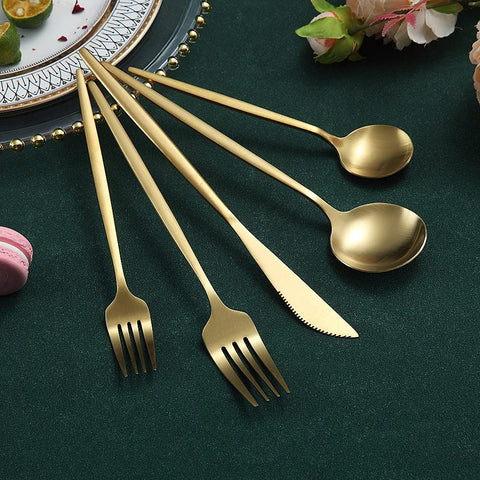 HOMQUEN matte gold silverware beside wine glasses for stylish entertaining.