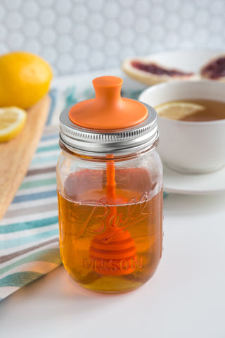 Honey drips around the Jarware dipper inside the lid