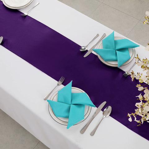 Horbaunal purple satin table runner at a wedding setup for refined ambiance.